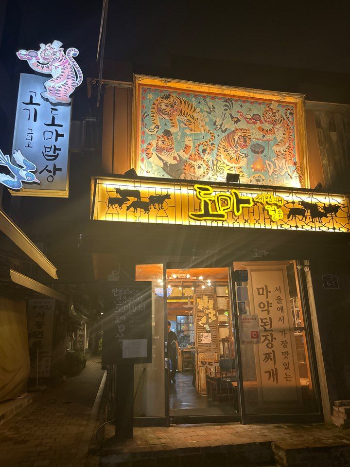 밤에 불을 밝힌 도마 인사동점 간판과 민화 호랑이 그림